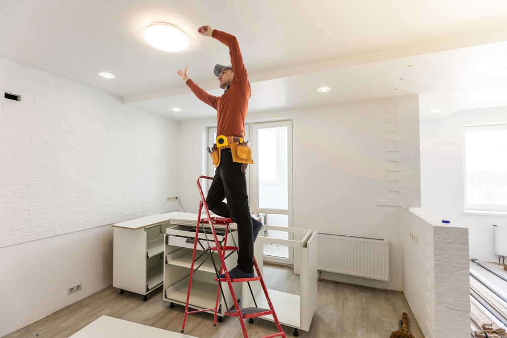 electrician repairing a light in an apartment